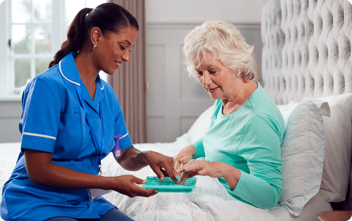 Nurse helping senior with pills